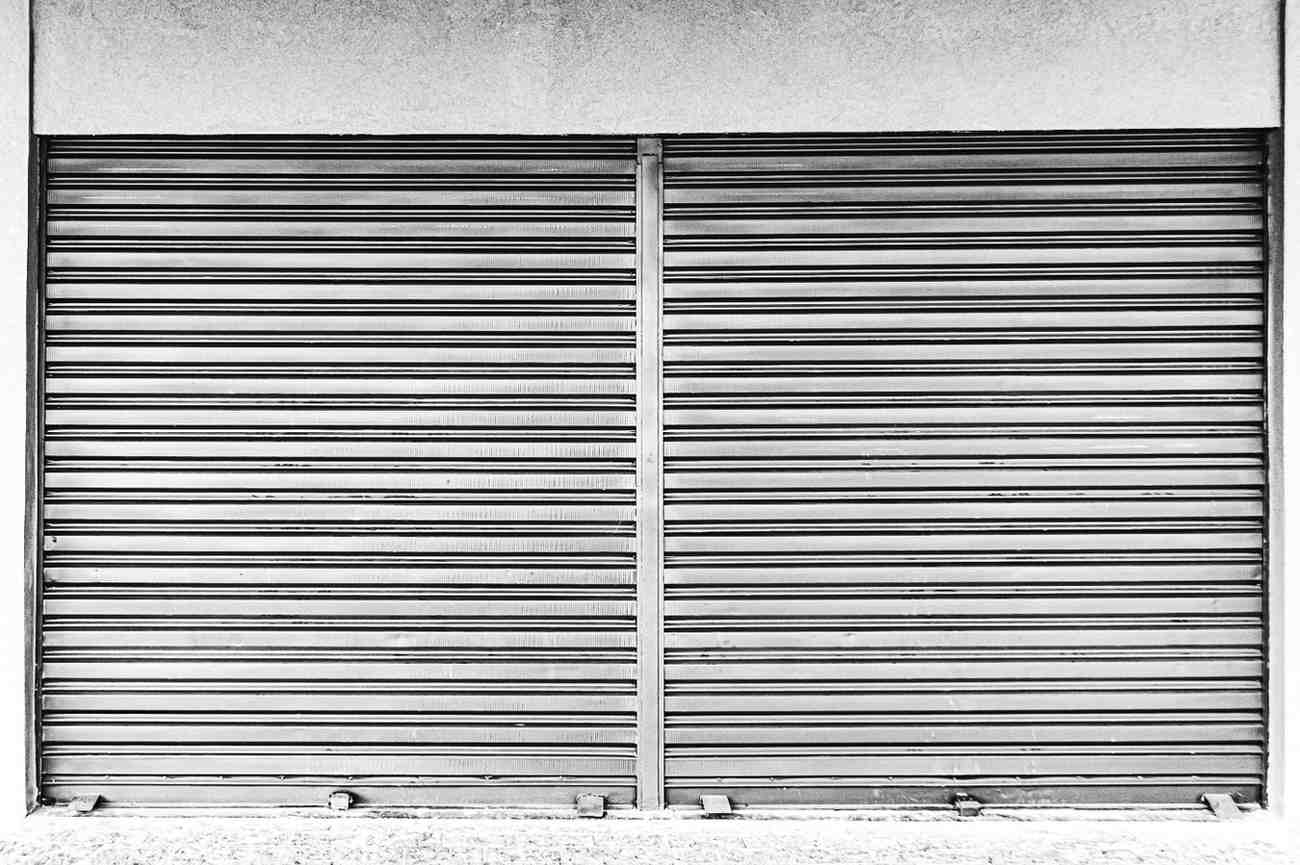 Motorized rolling shutter maintenance checklist with technician inspecting shutter and tools for smooth operation
